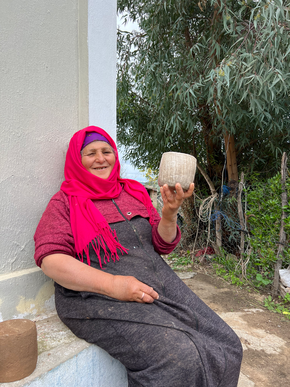 Chmissa smiling and holding a handmade Sejnane pot