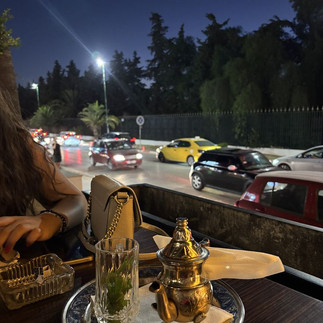 Urban street setting in Tunisia at night with café tables, where baguette farcie is commonly eaten