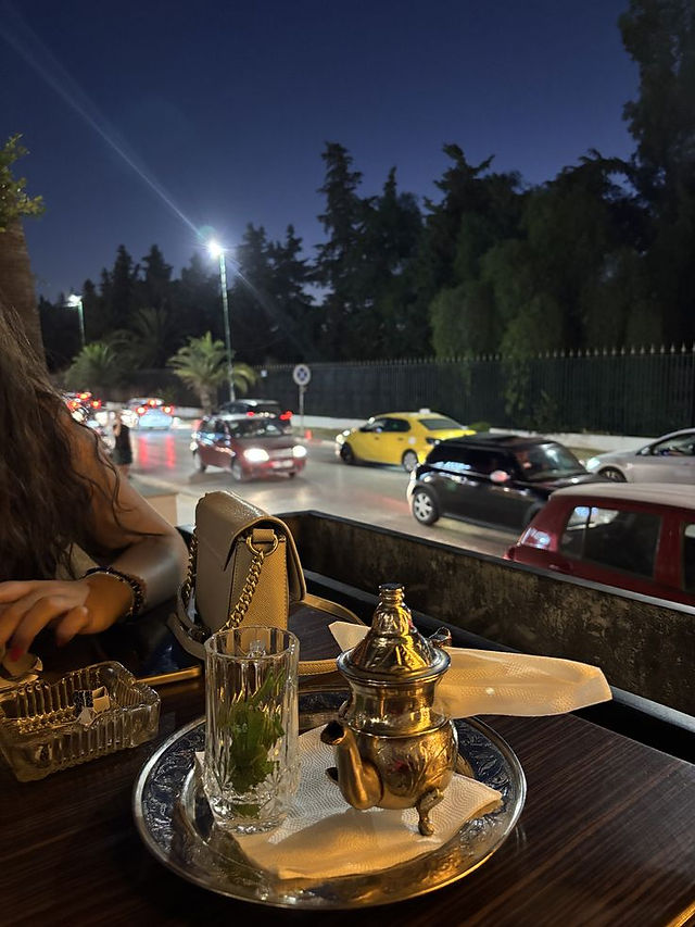 Urban street setting in Tunisia at night with café tables, where baguette farcie is commonly eaten