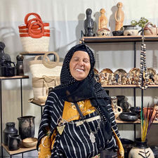 Tunisian artisan standing beside a display of handcrafted products presented through My Chakchouka.