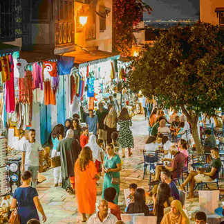 Crowded street in Sidi Bou Saïd with people walking and sitting in cafés at night
