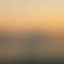 People by the sea at sunset in Tunisia with mountains visible in the distance