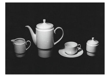 Zeitloses Industriedesign der DDR 1966. Ein Kaffeeservice der Formgestalterin Ellinor Symmangk enworfen und entwickelt im WTZ Meissen und produziert im Porzellanwerk Gehren. Im Foto zu sehen eine zylindrische Kanne mit elegantem Sockelfuss, modernem Deckelknauf und elegant geschwungenem Henkel, ein gedeck, eine Zuckerdose sowie ein Sahnekännchen.