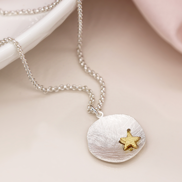 Silver plated scratched finish concave disc necklace with golden star close up