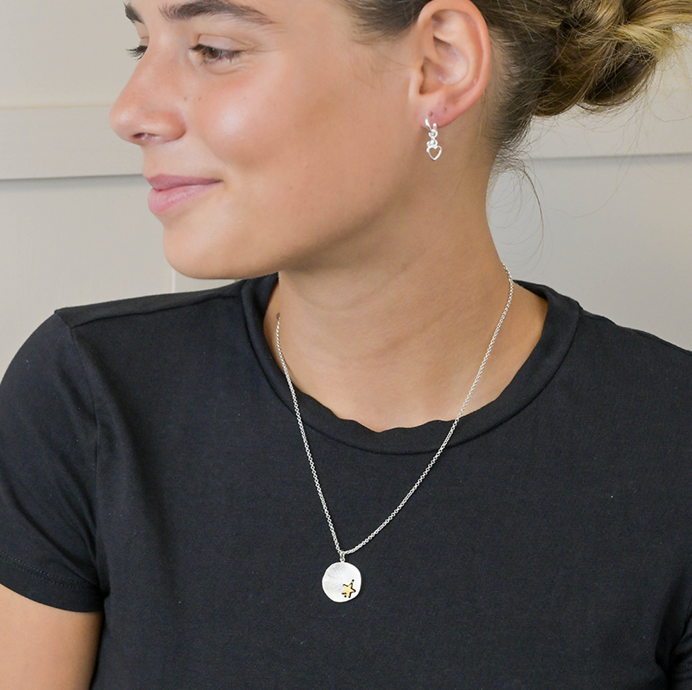 Model wearing Silver plated scratched finish concave disc necklace with golden star