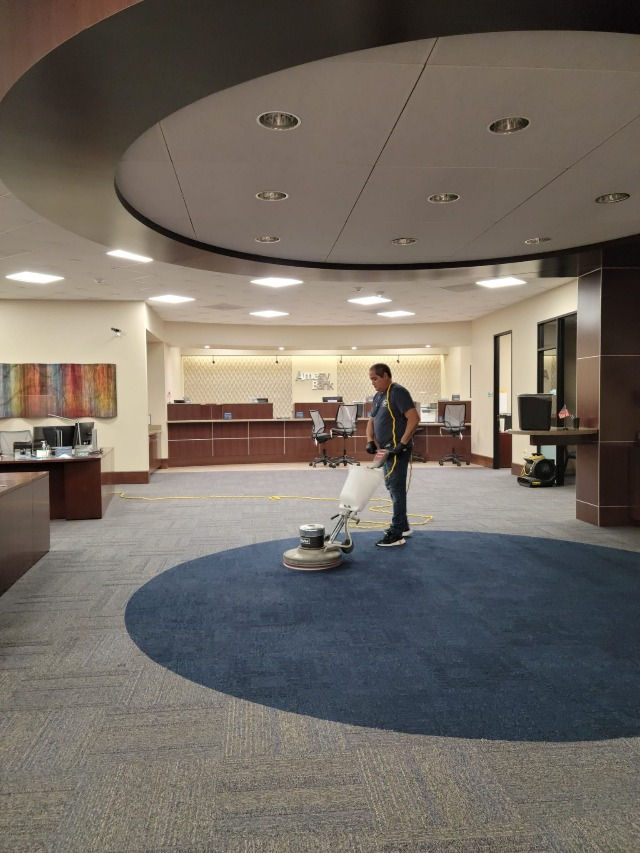 a man polishing a carpet in an office