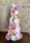 Three tier luxury pink watercolour wedding cake with cascade of fresh flowers Stratton Court Barn