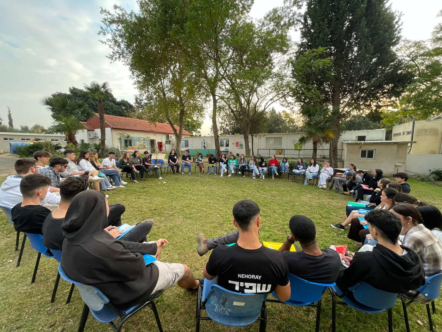Trainees sit on chairs in a circle