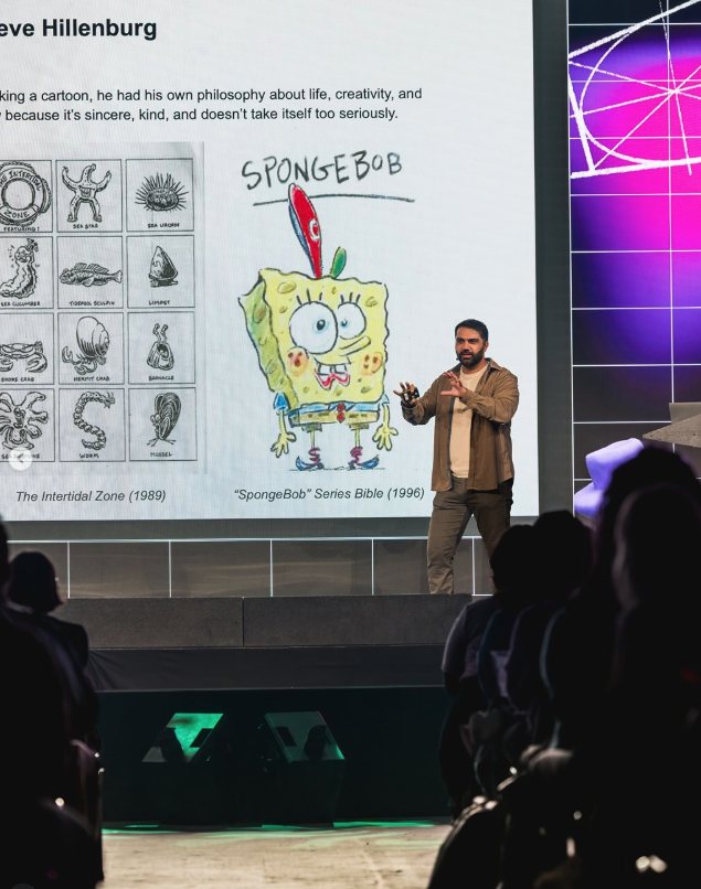 Adam on the Playgrounds stage beside a slide of Stephen Hillenburg's early SpongeBob designs