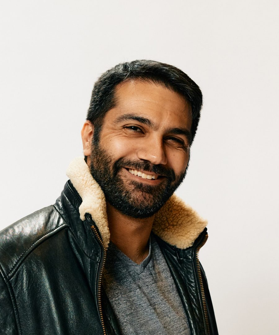 Portrait of Adam Paloian, smiling, in a brown leather jacket