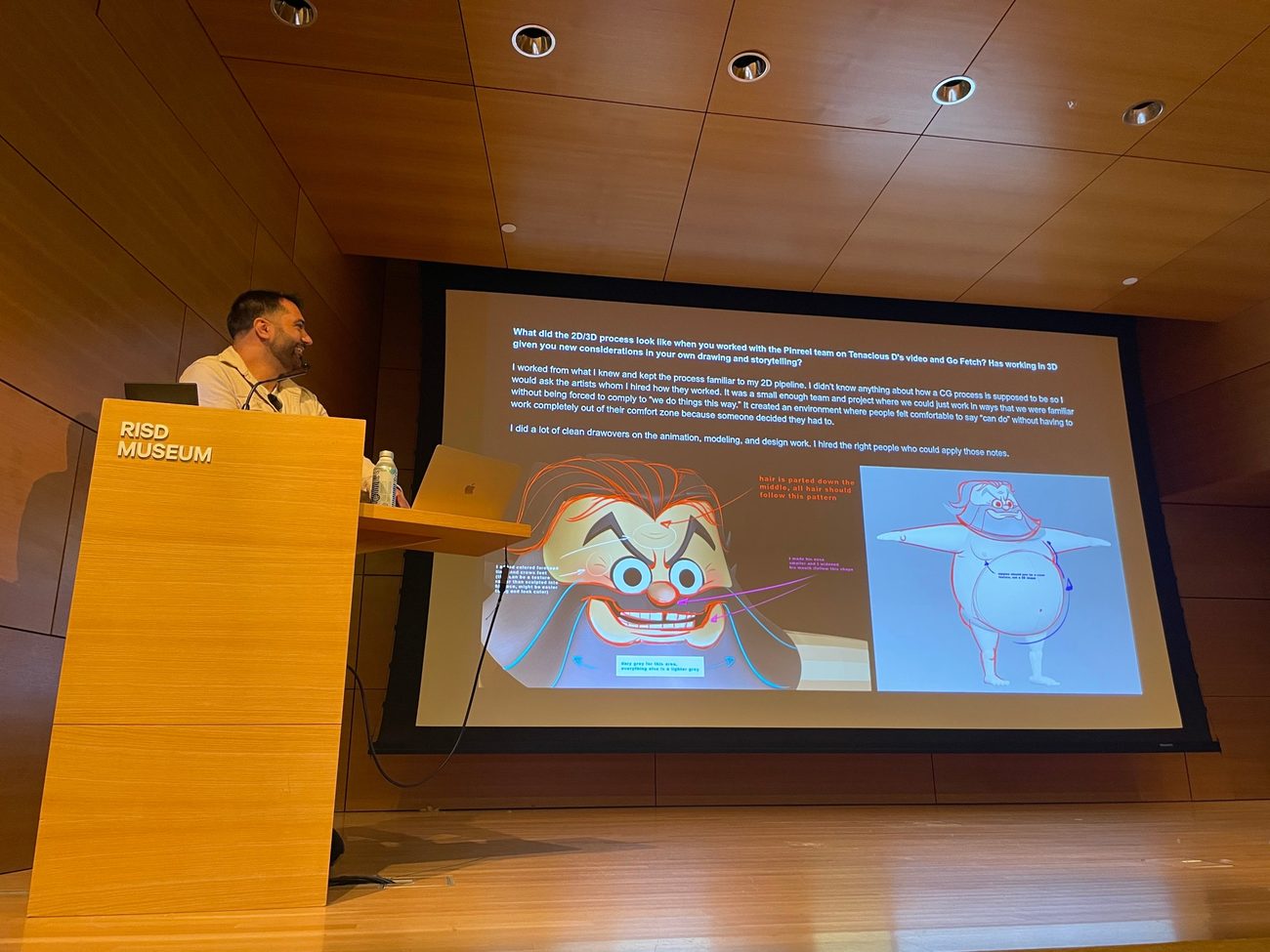 Adam speaking at the RISD Museum beside a slide of his drawovers on CG models