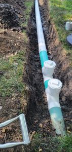Multiple clean out ports installed in a buried landscape drain pipe.