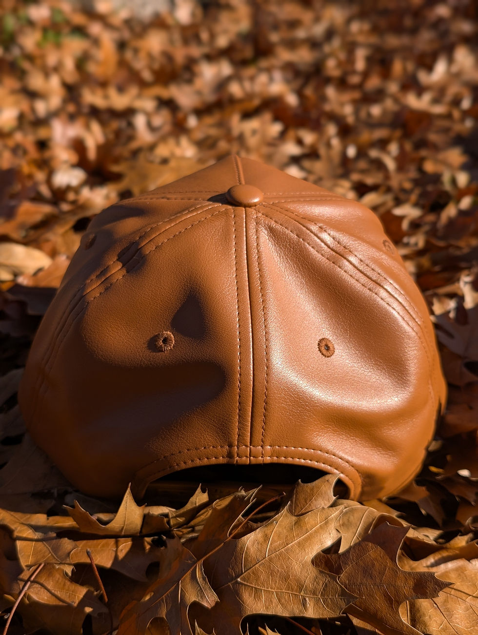 Thumbnail: Side view of brown leather snapback cap with structured five-panel design and stitched brim, inspired by Jamaican heritage.