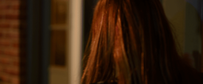 Two clips - each have a girl in tungstun/orange hued lighting looking sad