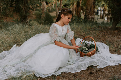 Niña posando en la naturaleza con un vestido de comunión y flores en Almuñecar