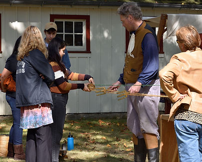 visitors and a demonstrator making rope