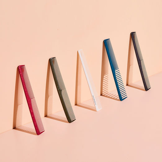 Cleanes Produktfoto von Haarbürsten vor einem minimalistischen Hintergrund in einem interessanten Winkel.