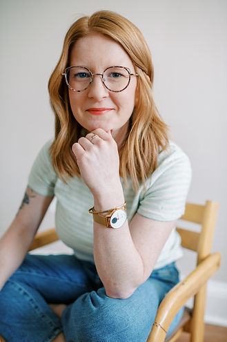 Woman sitting in a chair smiling wearing a watch.