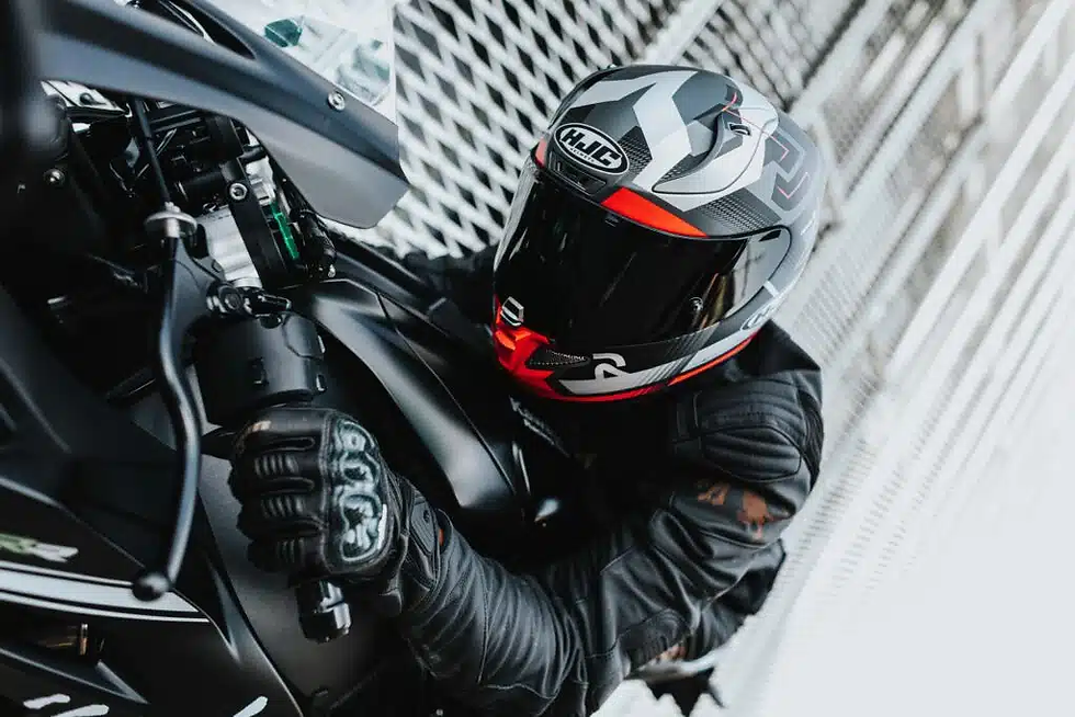 un motard qui s'apprête au départ et qui met en valeur son casque