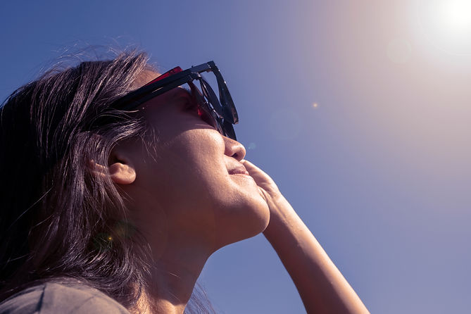 Woman is looking on solar eclipse through three sunglasses. Sun eclipse concept..jpg