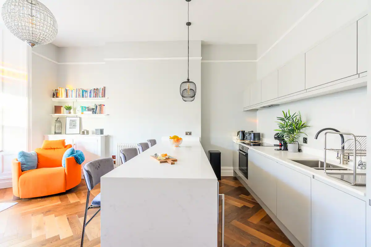 bright and airy kitchen featuring white cabinetry, countertops, and appliances, creating a clean and modern aesthetic
