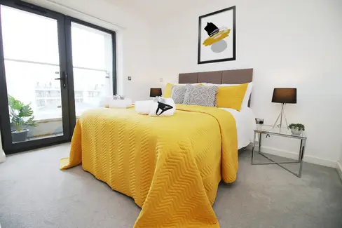 Bedroom featuring yellow decor accents, including bedding, pillows, creating a bright and cheerful ambiance