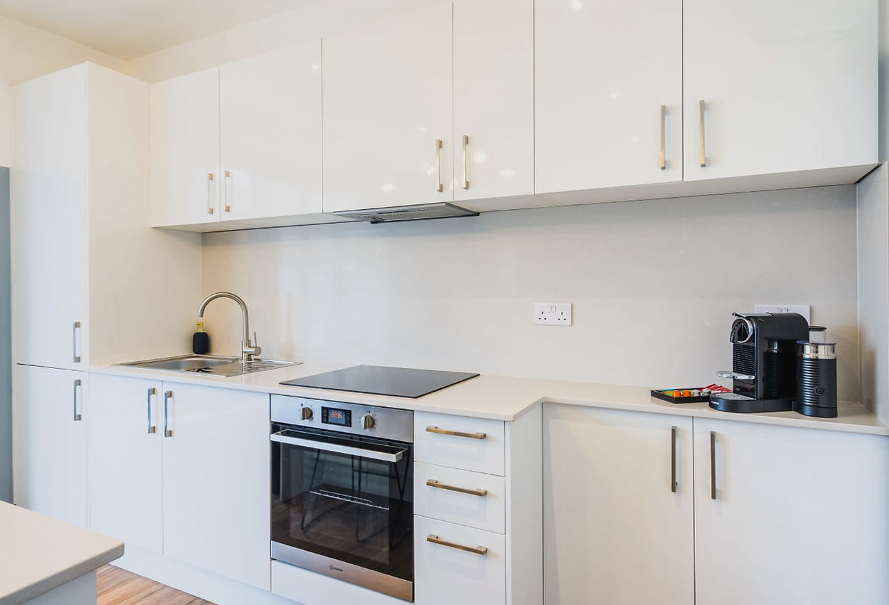 Sleek, modern kitchen with white walls, a black oven, and a minimalist, clean design