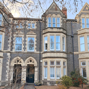 Victorian-style stone townhouse with arched windows and doors, surrounded by bare trees and shrubs in Pontcanna.