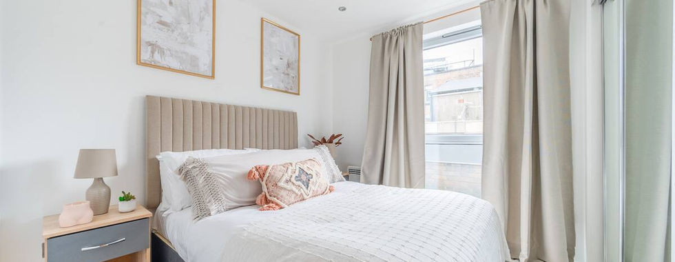 Cozy bedroom in Marsh House, Bristol, featuring a comfortable bed with plush pillows, soft lighting, and stylish decor, creating a warm and inviting atmosphere for relaxation