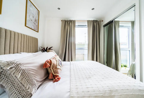 Comfortable bed with luxurious Egyptian cotton bedding, including crisp white sheets and fluffy pillows