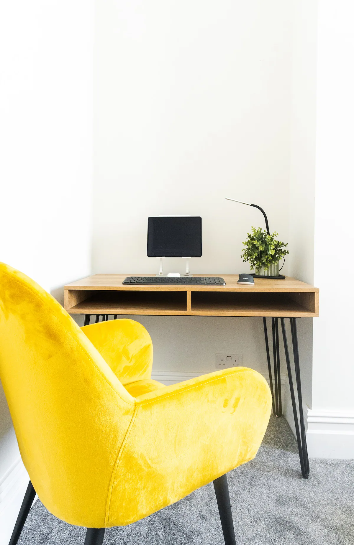 Workspace featuring a yellow chair, desk, and minimalistic decor, offering a vibrant and inviting environment for productivity