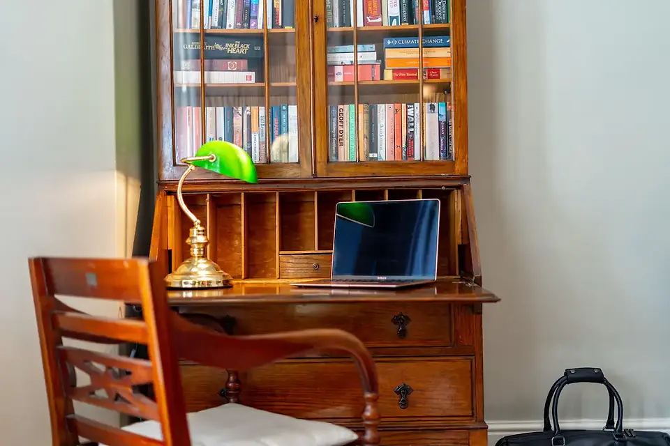 A desk with a comfortable chair, laptop, and stationery, ideal for business travelers or remote workers