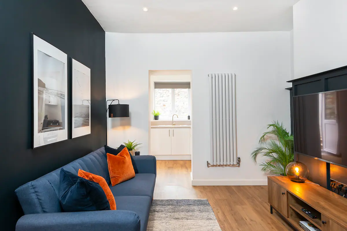 Living room adorned in a striking combination of dark blue and vibrant orange hues, with contrasting furniture and decor, creating a bold and energetic atmosphere