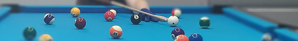 Cool perspective image of a pool player bent over the table with bright pool balls in the foreground