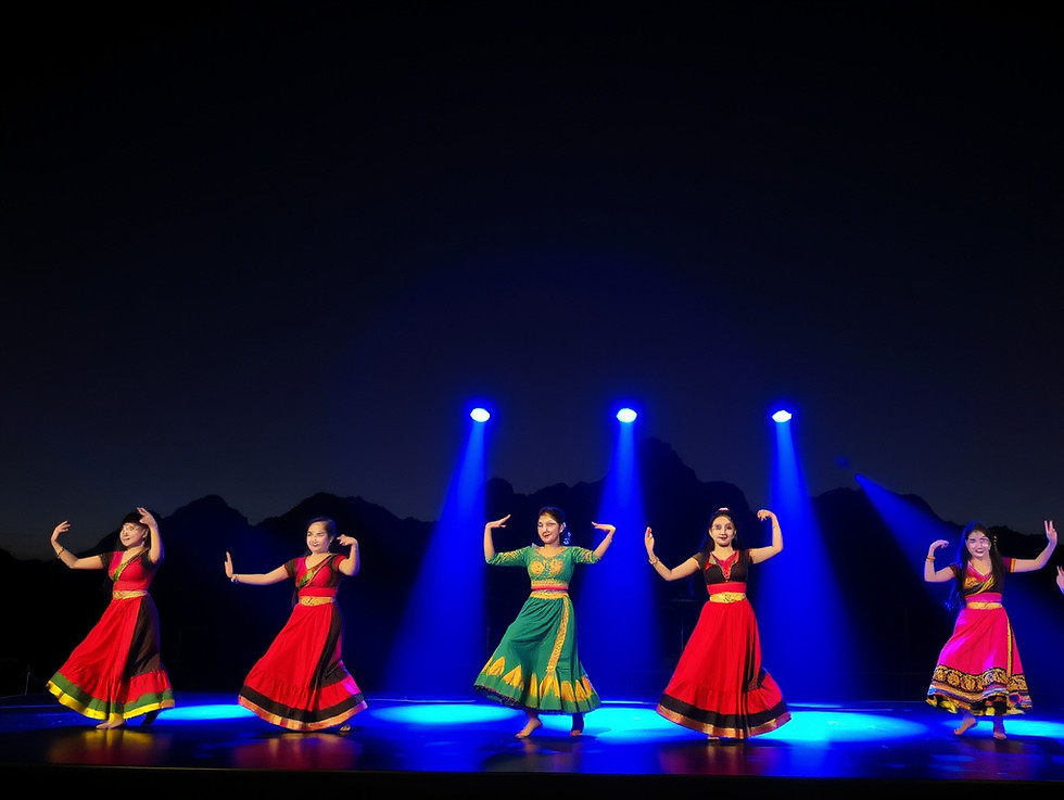 Impression Dali show — performers on a large open‑air stage, with Cangshan Mountain lit up