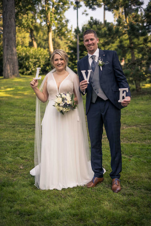 Brautpaar mit LOVE-Deko im Garten des Parkhotels Velbert – Hochzeitsfotograf NRW