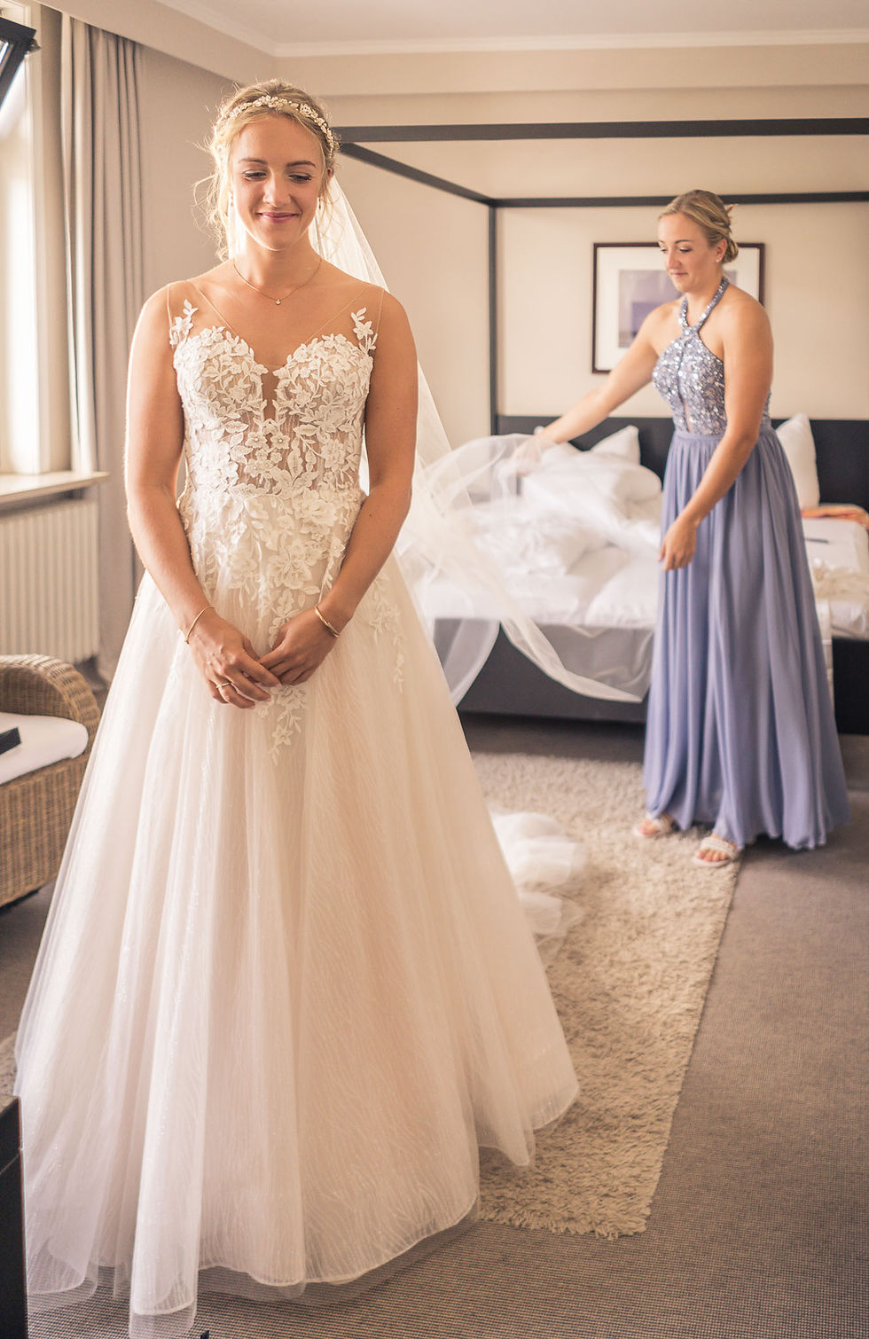 Trauzeugin hilft der Braut beim Ankleiden vor der Hochzeit
