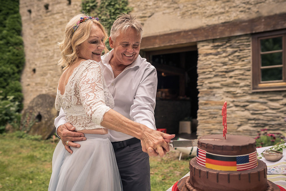 Tina und Jerry schneiden die Hochzeitstorte mit deutscher und amerikanischer Flagge an