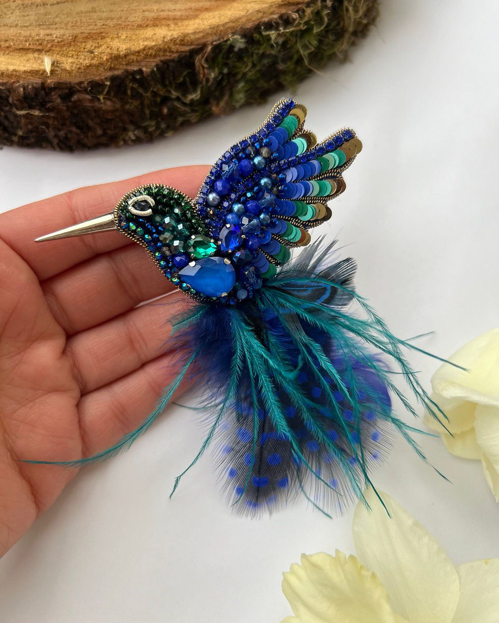 Ar rokām darināta piespraude "Kolibri ar spalvām"