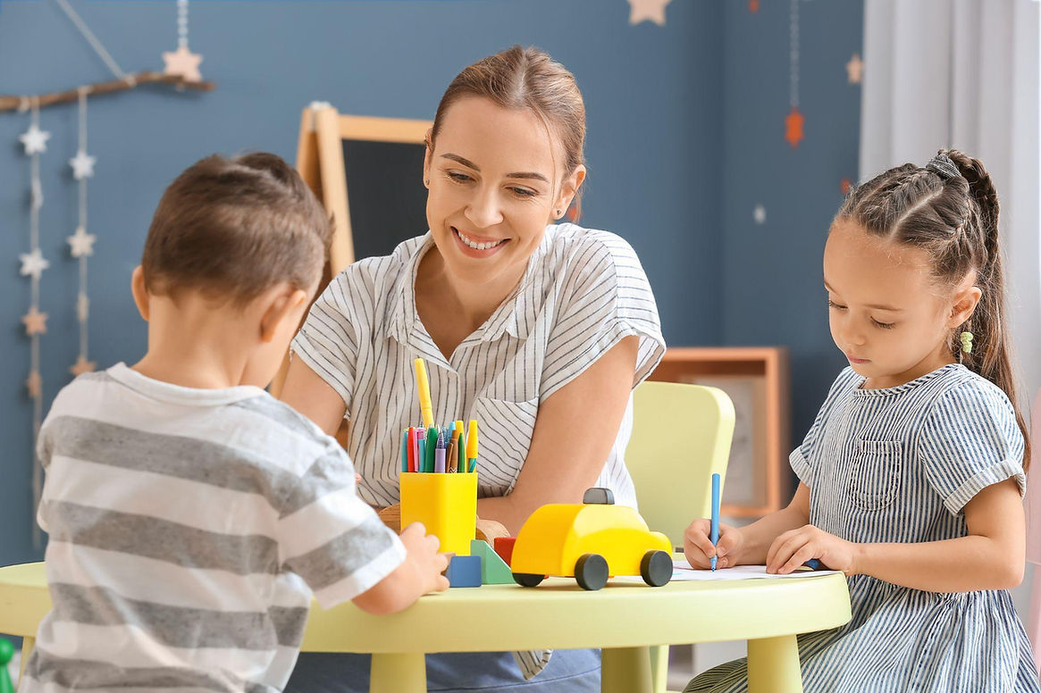 nanny-playing-with-kids-at-a-table.jpg