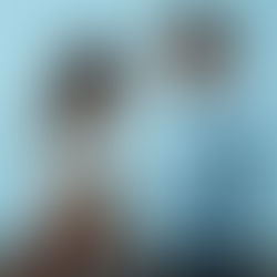 A brunette woman and dark-haired man talking together on a blue background.