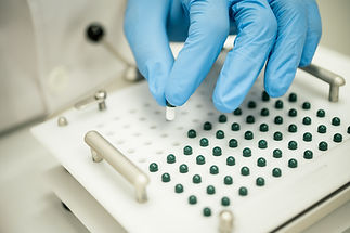 Crop compounding pharmacist putting pill into capsule filler.jpg