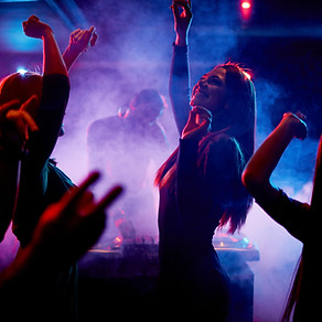 Groupe d'amis en train de danser devant un DJ lors d'une soirée privée