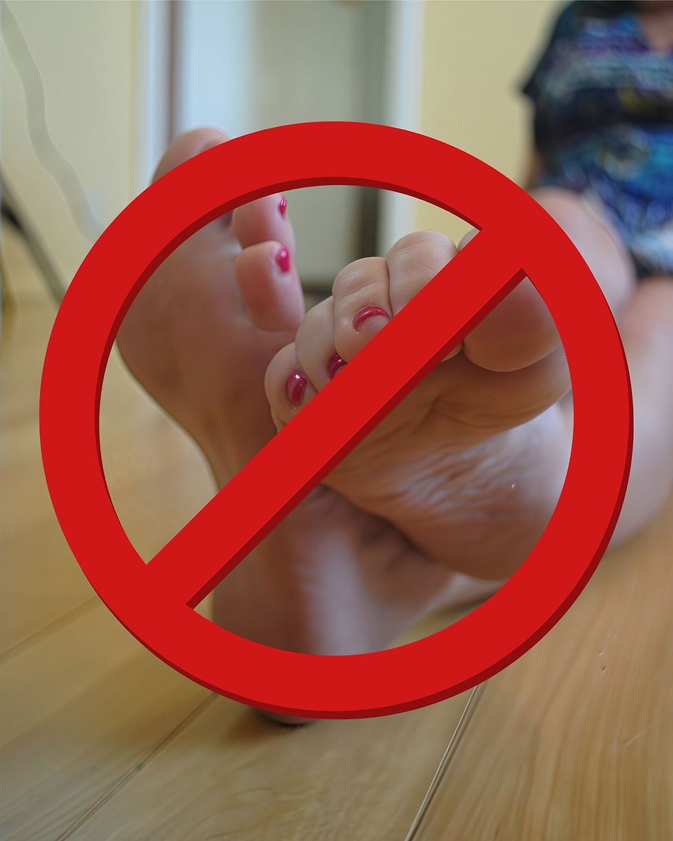 Feet with painted toenails on a wooden floor, overlaid with a red "no" symbol sign. Person in colorful attire blurred in the background.