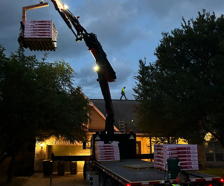 Crane unloading Owens Corning asphalt shingles during a Wimberley, TX storm damage roof replacement project.