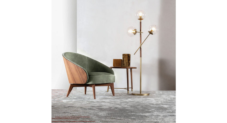 Zelena fotelja pored lampe i stolića, moderan dizajn enterijera. Ulivi Salotti