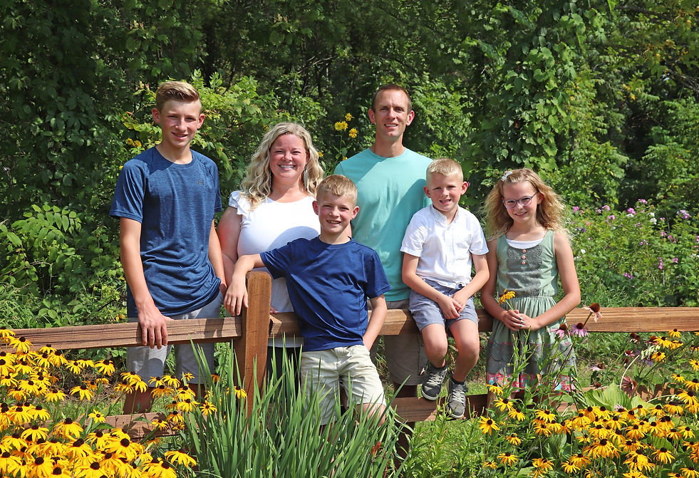 Crystal with her husband and children, surrounded by blooming flowers – a glimpse into her life as a wife and mother.