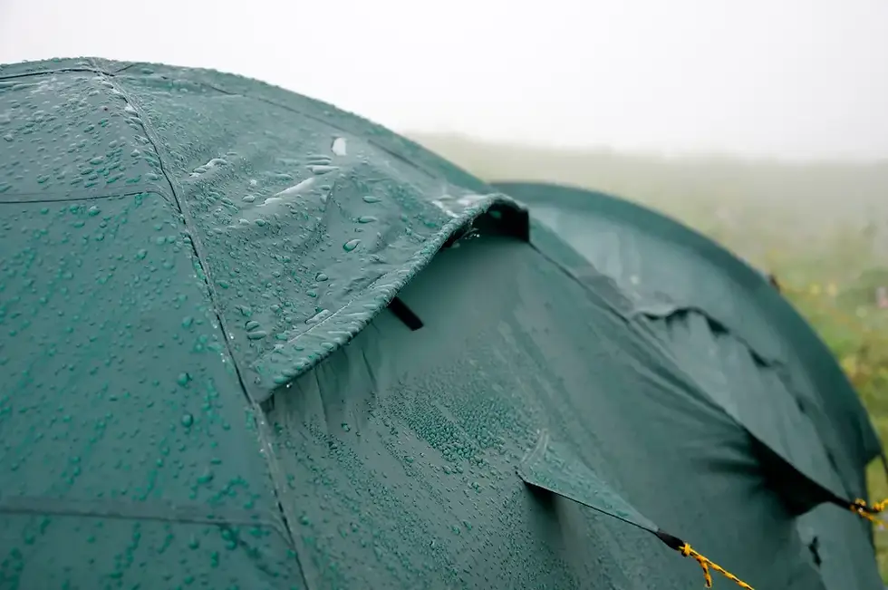 Green tent covered in raindrops