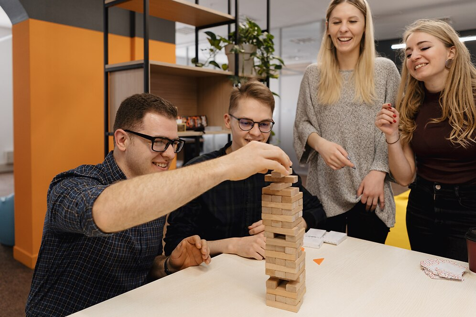 "A group of colleagues enjoying a break and playing a game of Jenga in a relaxed office environment."