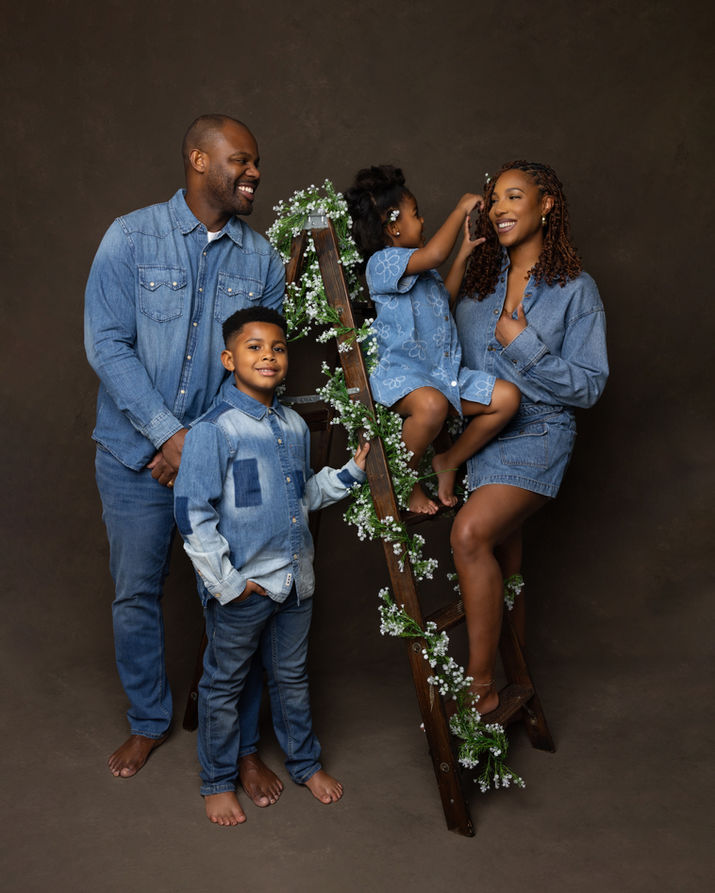 Happy family of four in denim with ladder